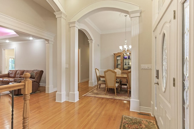 203 Foxwood Ct, Columbia, MO 65203 - foyer with arched walkways, light wood-style flooring, crown molding, ornate columns, and a chandelier