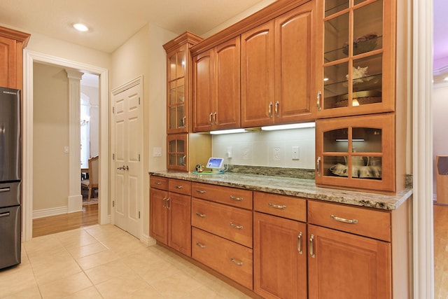 203 Foxwood Ct, Columbia, MO 65203 - kitchen with light stone counters, brown cabinetry, and recessed lighting
