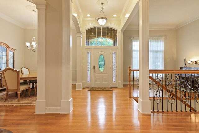 203 Foxwood Ct, Columbia, MO 65203 - entrance foyer with wood finished floors, plenty of natural light, a chandelier, crown molding, and decorative columns