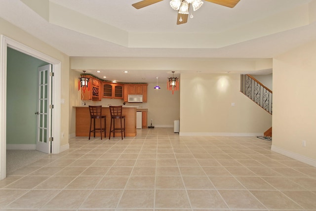 203 Foxwood Ct, Columbia, MO 65203 - living room with stairway, a tray ceiling, a ceiling fan, bar area, and light tile patterned flooring