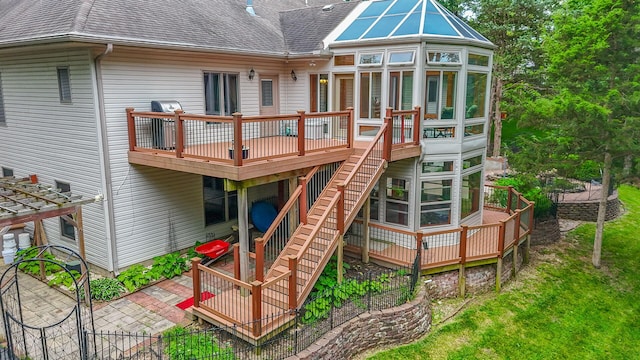203 Foxwood Ct, Columbia, MO 65203 - rear view of house featuring a sunroom, a wooden deck, a shingled roof, and stairway