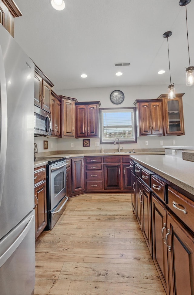 1600 Andretti Cir, Columbia, MO 65201 - kitchen featuring appliances with stainless steel finishes, light countertops, decorative light fixtures, light wood-style flooring, and recessed lighting