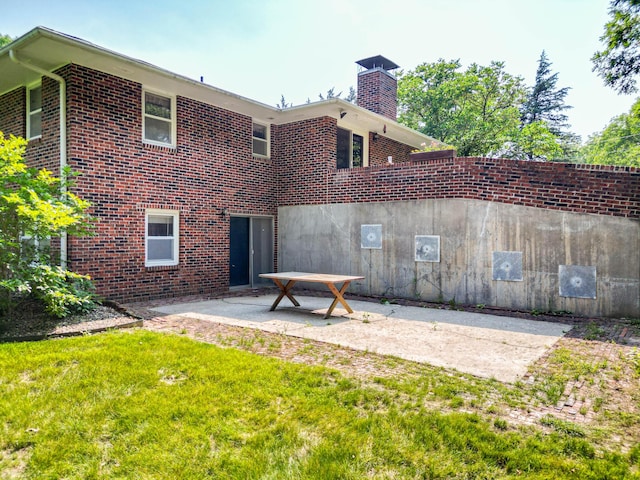 4705 Roemer Rd, Columbia, MO 65202 - rear view of property featuring a patio, a chimney, brick siding, and a lawn