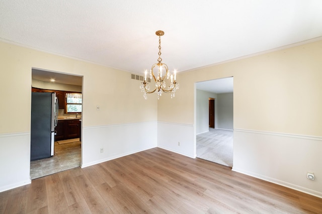 4705 Roemer Rd, Columbia, MO 65202 - spare room with a chandelier, light wood finished floors, and ornamental molding