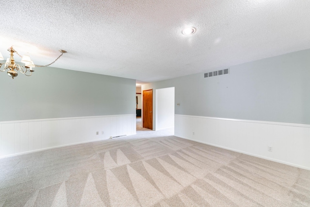 4705 Roemer Rd, Columbia, MO 65202 - empty room featuring a wainscoted wall, a chandelier, a textured ceiling, and light colored carpet