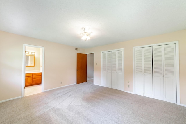4705 Roemer Rd, Columbia, MO 65202 - unfurnished bedroom featuring two closets, light carpet, and ensuite bath