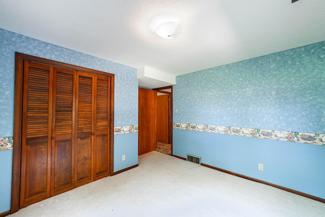 4705 Roemer Rd, Columbia, MO 65202 - unfurnished bedroom with wallpapered walls, carpet floors, and a closet