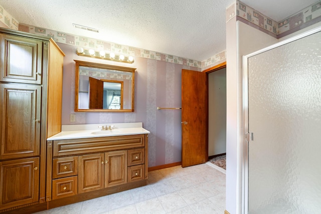4705 Roemer Rd, Columbia, MO 65202 - bathroom featuring a shower stall, vanity, wallpapered walls, a textured ceiling, and tile patterned flooring