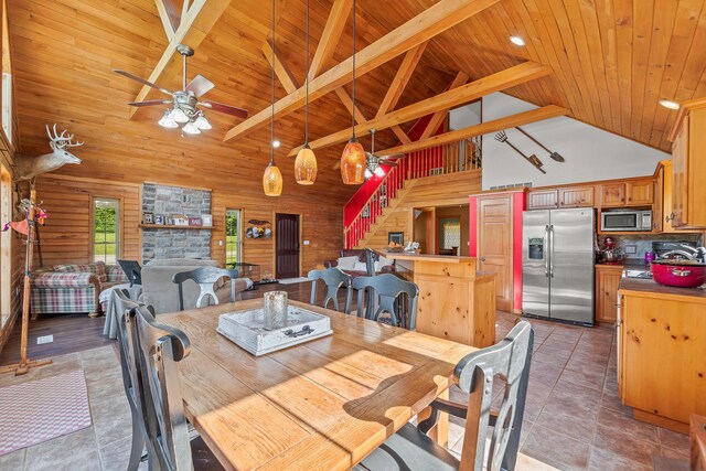 4604 County Road 115, Fulton, MO 65251 - dining space with a wooden ceiling with exposed beams, a ceiling fan, high vaulted ceiling, wooden walls, and stairs