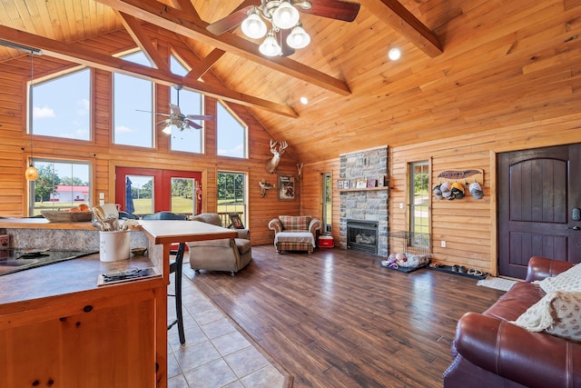 4604 County Road 115, Fulton, MO 65251 - living room with ceiling fan, high vaulted ceiling, a stone fireplace, a wooden ceiling with exposed beams, and wood walls