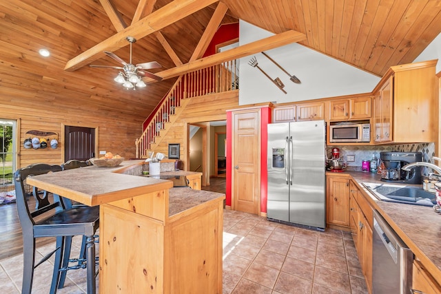 4604 County Road 115, Fulton, MO 65251 - kitchen featuring appliances with stainless steel finishes, high vaulted ceiling, a wood ceiling with exposed beams, a kitchen breakfast bar, and backsplash