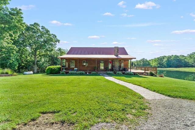 4604 County Road 115, Fulton, MO 65251 - view of front of house with a front yard, covered porch, a water view, and a metal roof