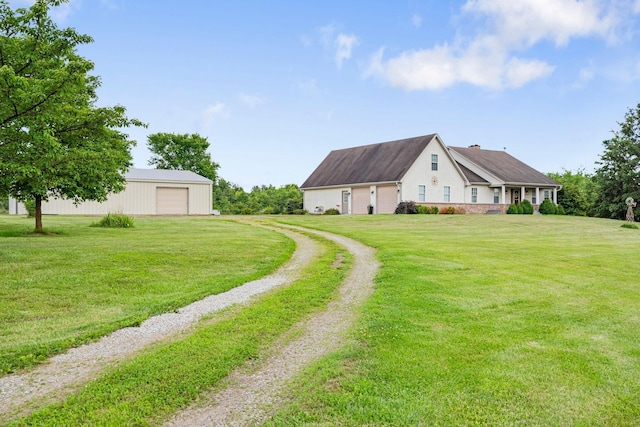 9050 Hartley Rd, Hallsville, MO 65255 - view of grassy yard featuring driveway, a garage, and an outbuilding