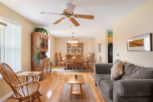 9050 Hartley Rd, Hallsville, MO 65255 - living room with plenty of natural light, light wood-type flooring, a ceiling fan, and a chandelier