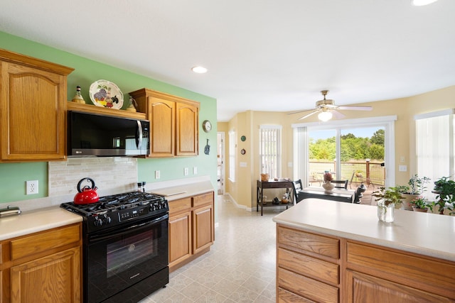 9050 Hartley Rd, Hallsville, MO 65255 - kitchen featuring black gas range oven, light countertops, ceiling fan, decorative backsplash, and light floors