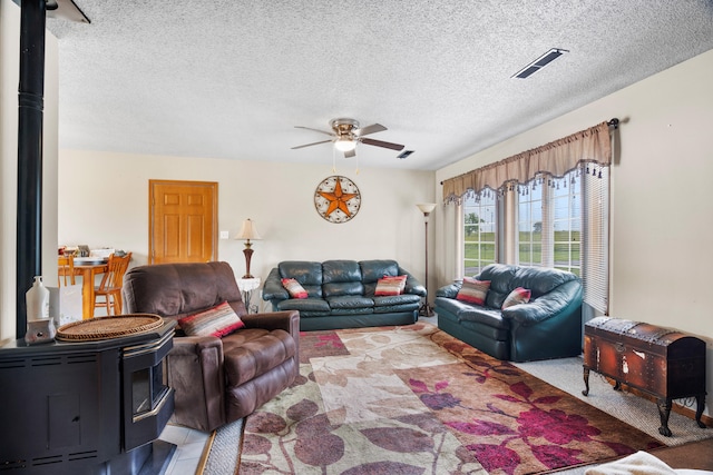7275 N Route E, Columbia, MO 65202 - living area with a wood stove, ceiling fan, and a textured ceiling