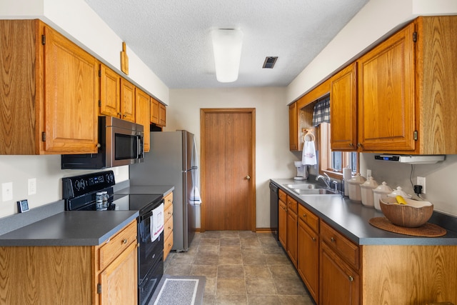 7275 N Route E, Columbia, MO 65202 - kitchen featuring black appliances, dark countertops, a textured ceiling, and brown cabinets