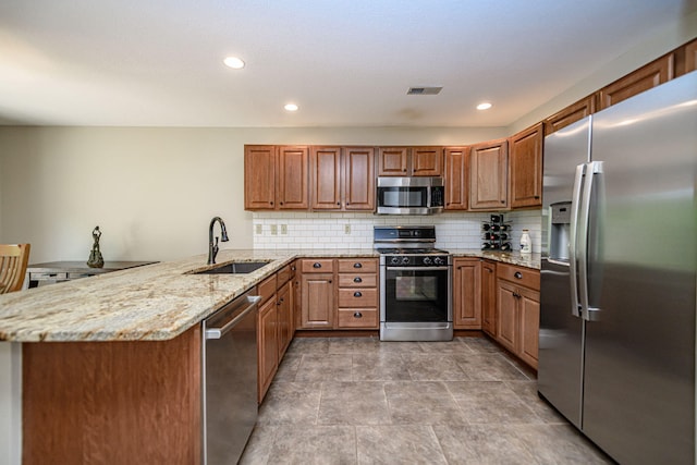 4504 Orrine St, Columbia, MO 65201 - kitchen featuring stainless steel appliances, a peninsula, brown cabinets, light stone countertops, and recessed lighting