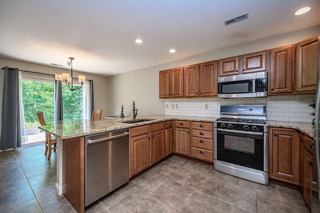 4504 Orrine St, Columbia, MO 65201 - kitchen with stainless steel appliances, a peninsula, a chandelier, decorative backsplash, and recessed lighting