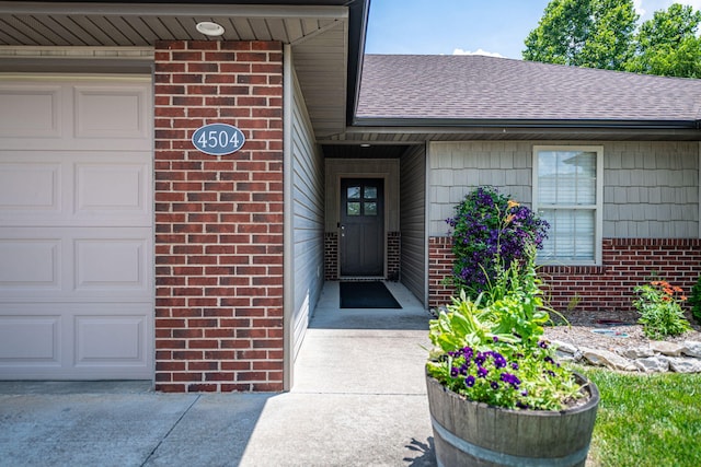 4504 Orrine St, Columbia, MO 65201 - view of exterior entry with brick siding, a shingled roof, and an attached garage