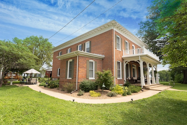 1001 Randolph St, Glasgow, MO 65254 - view of property exterior with covered porch, a yard, brick siding, and a balcony