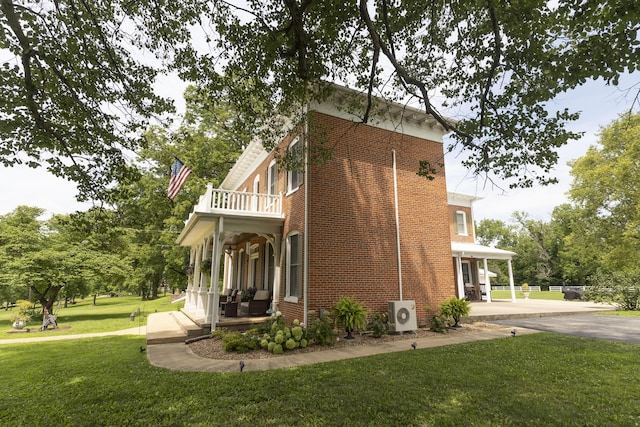 1001 Randolph St, Glasgow, MO 65254 - view of property exterior with a balcony, a yard, brick siding, and a porch