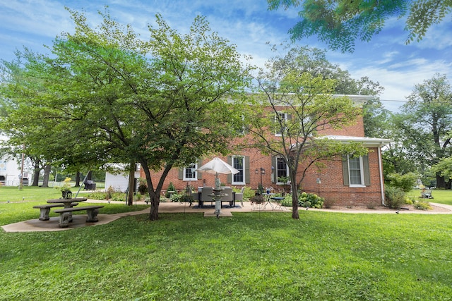 1001 Randolph St, Glasgow, MO 65254 - rear view of property featuring brick siding, a lawn, and a patio