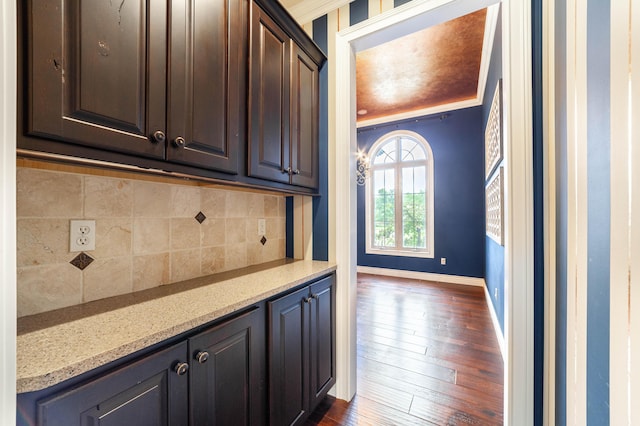 3903 Foxcreek Way, Columbia, MO 65203 - kitchen with dark wood-type flooring, decorative backsplash, dark brown cabinetry, and light stone counters