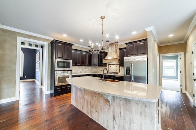 3903 Foxcreek Way, Columbia, MO 65203 - kitchen featuring stainless steel appliances, crown molding, a chandelier, dark wood-style floors, and a center island with sink