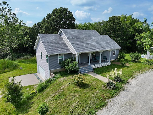 3045 State Rd, Aa, Holts Summit, MO 65043 - view of front of home with covered porch, driveway, an attached garage, and a front lawn