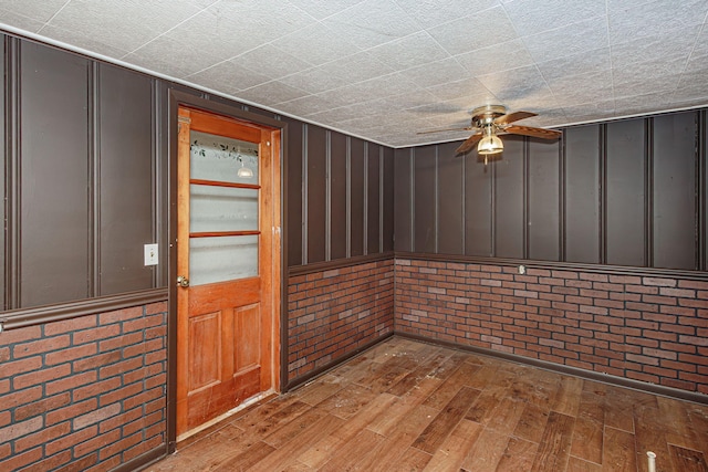 4741 E N Rte E, Columbia, MO 65202 - unfurnished room featuring hardwood / wood-style flooring, a ceiling fan, and brick wall
