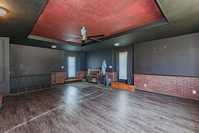 4741 E N Rte E, Columbia, MO 65202 - living room with wood finished floors, a wainscoted wall, a ceiling fan, healthy amount of natural light, and brick wall