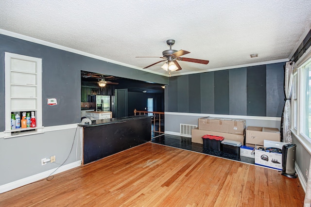 4741 E N Rte E, Columbia, MO 65202 - unfurnished living room featuring ceiling fan, a textured ceiling, ornamental molding, and wood finished floors