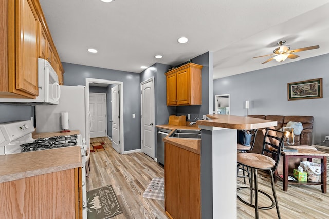 6610 Chrissula Ln, Columbia, MO 65203 - kitchen featuring gas stove, a kitchen breakfast bar, stainless steel dishwasher, light wood-type flooring, and a peninsula