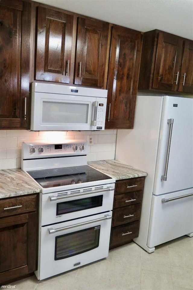 1902 Park Deville Pl, Columbia, MO 65203 - kitchen with white appliances, dark brown cabinets, light tile patterned floors, and backsplash