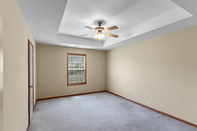 2208-2210 Shamrock Dr, Columbia, MO 65202 - spare room featuring a tray ceiling, a ceiling fan, and light carpet
