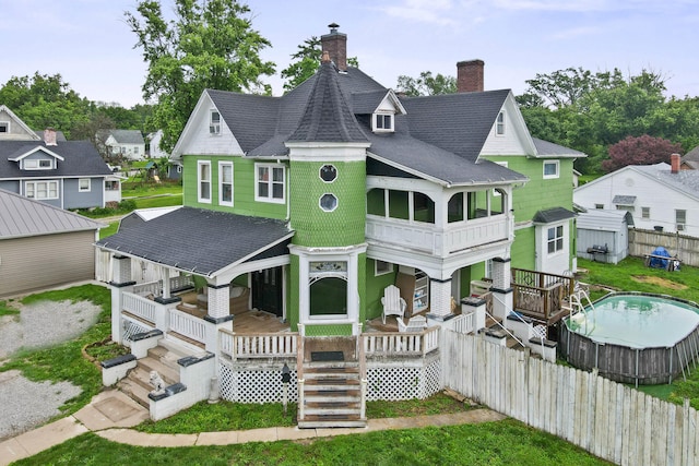 704 N Jefferson St, Mexico, MO 65265 - back of property with covered porch, a chimney, a shingled roof, and stairway