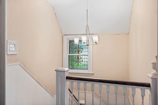 704 N Jefferson St, Mexico, MO 65265 - stairs with a chandelier, vaulted ceiling, and a wainscoted wall
