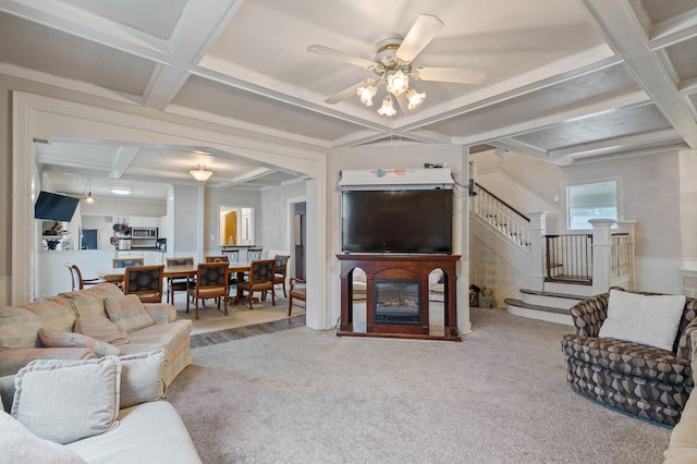 704 N Jefferson St, Mexico, MO 65265 - carpeted living room featuring coffered ceiling, stairway, beamed ceiling, ceiling fan, and a glass covered fireplace