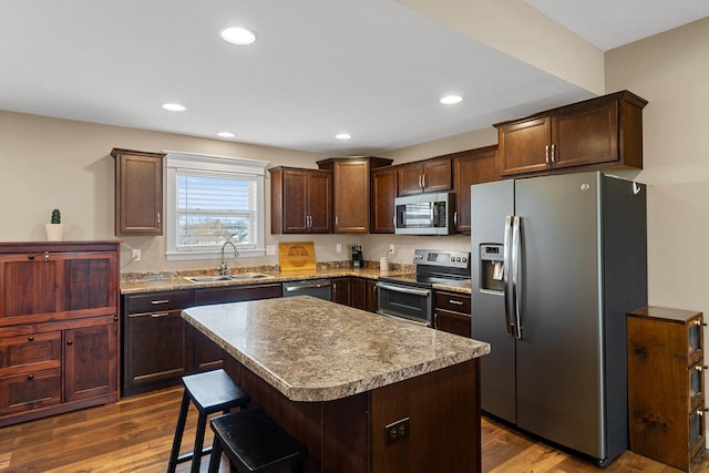 4969 W Red Tail Dr, Ashland, MO 65010 - kitchen featuring appliances with stainless steel finishes, dark wood finished floors, a kitchen breakfast bar, a center island, and dark brown cabinets