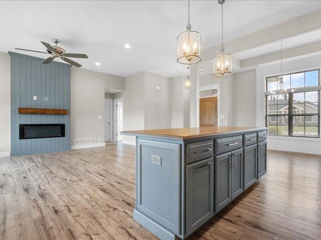 5204 Newbury Way, Columbia, MO 65203 - kitchen with wood finished floors, a large fireplace, ceiling fan, a chandelier, and gray cabinets