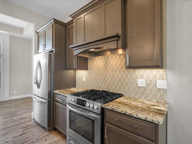 5204 Newbury Way, Columbia, MO 65203 - kitchen with stainless steel appliances, light wood finished floors, backsplash, and light stone countertops