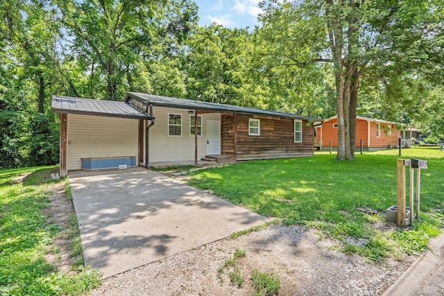 504 1st St, Boonville, MO 65233 - view of front of home with entry steps, driveway, a front lawn, and a metal roof