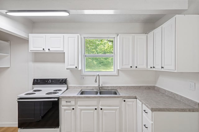 504 1st St, Boonville, MO 65233 - kitchen with electric range, white cabinets, and light countertops