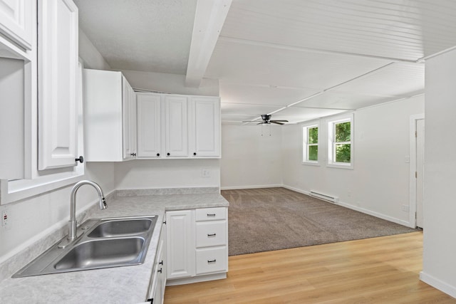 504 1st St, Boonville, MO 65233 - kitchen featuring ceiling fan, white cabinetry, light countertops, and baseboard heating