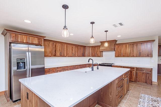 902 S Cedar Grove Blvd, Columbia, MO 65201 - kitchen featuring stainless steel fridge with ice dispenser, light countertops, brown cabinets, a kitchen island with sink, and recessed lighting
