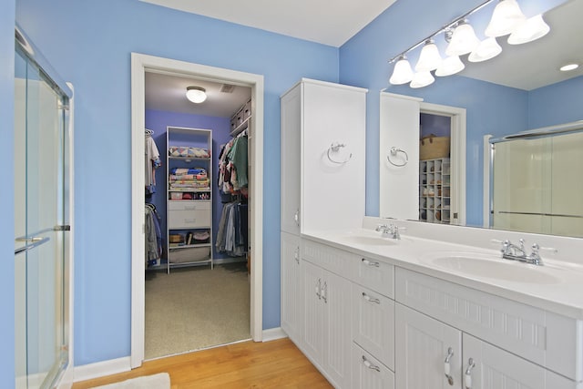 5200 N Locust Grove Church Rd, Columbia, MO 65202 - bathroom featuring a shower stall, a spacious closet, double vanity, and wood finished floors