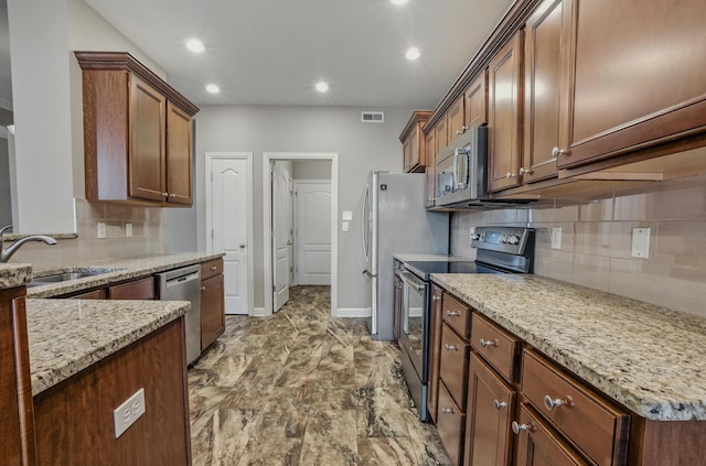 3904 Ivanhoe Blvd, Columbia, MO 65203 - kitchen featuring appliances with stainless steel finishes, decorative backsplash, light stone countertops, and recessed lighting