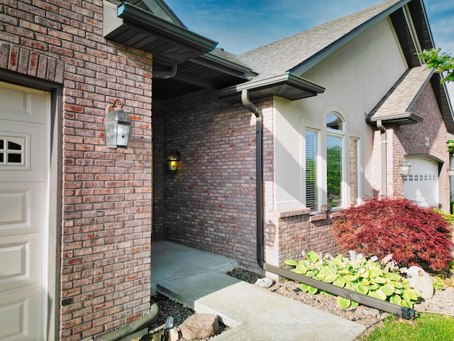 3904 Ivanhoe Blvd, Columbia, MO 65203 - property entrance featuring brick siding, a garage, a shingled roof, and stucco siding