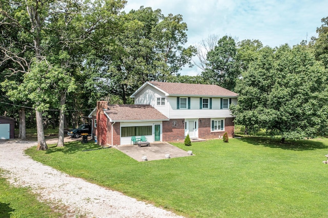 3674 State Road Aa, Holts Summit, MO 65043 - view of front of home with brick siding, a patio area, a front lawn, and view of wooded area